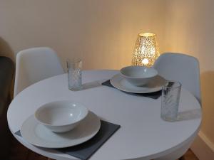 利物浦Marmaduke Apartments - Entire Apartment Close to City Centre的一张带两个碗和眼镜的白色桌子