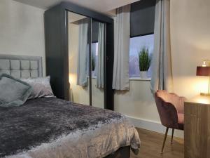 利物浦Marmaduke Apartments - Entire Apartment Close to City Centre的一间卧室配有一张床和一个带椅子的窗户