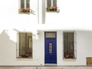 锡切斯西特格斯乡间公寓的白色的建筑,设有蓝色的门和窗户