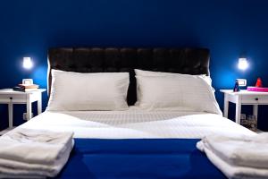 那不勒斯NAPOLI IN BLU MAISON的蓝色卧室配有带白色床单和枕头的床