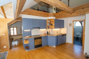 施库尔Apartment Bügl Grond 124的厨房铺有木地板,配有蓝色橱柜。