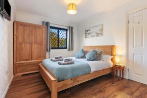 桑德斯富特Hazelglade Cottage - Hot Tub, Games Room, Pet Friendly的一间卧室设有一张床和一个窗口