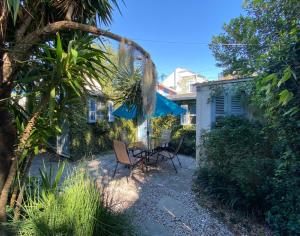 新奥尔良Antonine Apartment Upper Garden District的庭院配有两把椅子和蓝伞