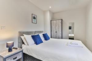 谢菲尔德3 Bed Refurbished, Modern House, WiFi, Patio area by Ark SA的卧室配有带蓝色枕头的大型白色床