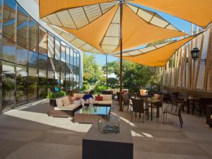 圣地亚哥维塔库拉董事酒店的一座带桌子和遮阳伞的庭院