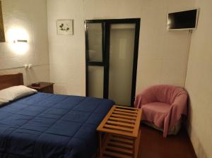 蓬塔德尔加达瓦拉多斯公寓的一间卧室配有蓝色的床和粉红色的椅子