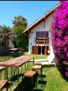 门多萨Tanino Guest House的一座带粉红色花卉的建筑前的野餐桌