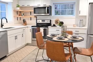 西雅图Modern and warm house的厨房配有白色橱柜和桌椅