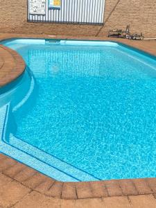 达博四季汽车旅馆的大楼内的一个蓝色海水游泳池