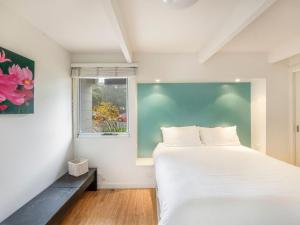 莫里莫科Tallwoods Beach House的卧室配有白色的床和窗户。