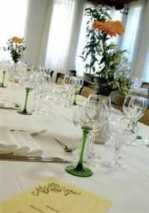 Casale Corte Cerro奥伯格西恩酒店的一张桌子,上面放着酒杯和鲜花