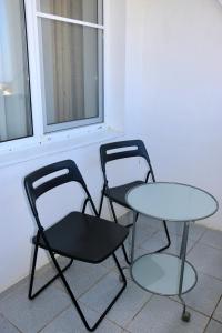 戈卢比茨卡亚Mini-Hotel Morskoi rif的窗边的两把椅子和一张桌子