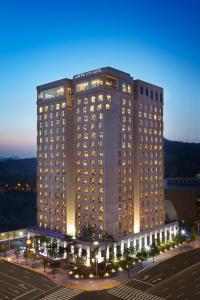 大田LOTTE City Hotel Daejeon的停车场前有灯的大建筑