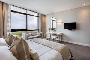 AmsterdamhoekBluewater Bay Sunrise Hotel的一间卧室配有一张床、一张书桌和一台电视