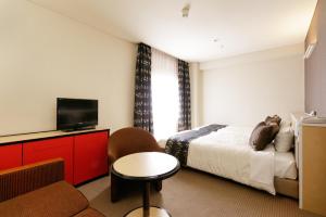 福岛吨详福岛旅馆的一间酒店客房,配有一张床和一台电视