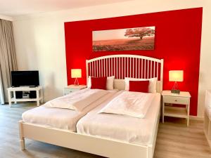巴德贝芬森Haus Heidelerche das ThermePlus-Haus的一间卧室设有一张红色墙壁的大床