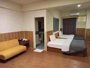 Wenquan九族飯店 臺東縣旅館004號的一间卧室配有一张床和一个沙发