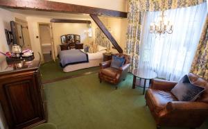 克里克豪厄尔力推克里克豪威尔大熊酒店的一间卧室配有一张床、一张沙发和椅子
