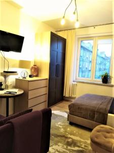 格但斯克Wygodny Apartament w Śródmieściu Gdańska的一间卧室配有一张床、一张书桌和一台电视。
