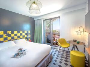 耶尔耶尔中心蔚蓝海岸美居酒店的酒店客房设有床、桌子和窗户。