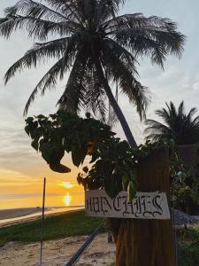 班泰Munchies Bungalows的棕榈树海滩上的标志