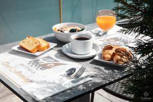 梅塔诺佛希斯4-you Boutique的一张桌子,上面有早餐食品和一杯橙汁