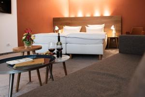 阿斯佩格Hotel Adler Asperg的酒店客房带一张床和两杯葡萄酒