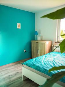 ZłatnaDomek w Górach na wyłączność的一间蓝色的卧室,配有一张床和一个木制橱柜