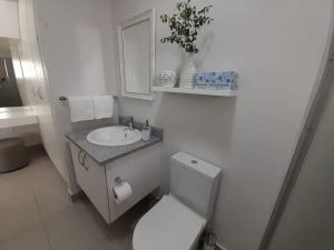 约翰内斯堡Kent Manor Guest Suites的白色的浴室设有卫生间和水槽。