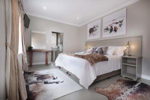 罗伯森Adderley House Guest Accommodation的卧室配有一张带白色墙壁的大床