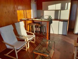 米纳斯Bungalow de campo Nabucco - sierras, naturaleza y descanso的厨房配有白色的椅子和玻璃桌