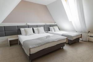 塔干尼采Kocierz Resort - Hotel的一间卧室设有两张床和大窗户
