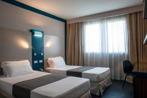 佩鲁贾拉梅利笛安娜酒店的酒店客房设有两张床和窗户。