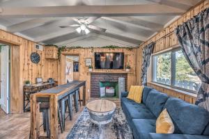 鲁伊多索Cabin with Mountain Views about 2 Mi to Ruidoso Midtown!的客厅设有蓝色的沙发和壁炉