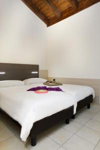 托尔博莱玛洛阿迪酒店的卧室配有一张白色大床和木制天花板