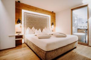 图克斯Alpinhotel Berghaus spa的一间带大床的卧室和一间浴室
