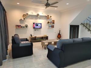 金宝U&I HOMESTAY KAMPAR的客厅配有2张蓝色沙发和电视