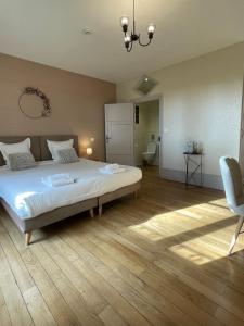 帕雷·勒·毛尼尔La Maison Verneuil的一间卧室配有一张大床和一把椅子