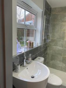 比肯希尔Arden House NEC Birmingham的一间带水槽和卫生间的浴室以及窗户。