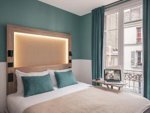 巴黎宜必思巴黎蒙马特尔北酒店的一间卧室配有一张蓝色墙壁的床和一扇窗户