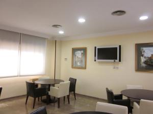 格拉纳达伊琳娜玛丽亚酒店的一间设有桌椅和平面电视的等候室