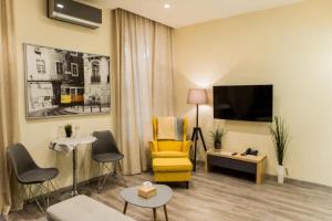 敖德萨Malon apartments的客厅配有黄色椅子和电视