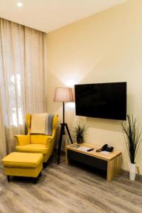 敖德萨Malon apartments的客厅配有黄色椅子和电视