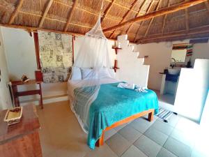 巴卡拉尔Veleando Ando Cabañas的一间卧室配有一张带蚊帐的床