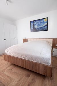 迈泽克韦什德HVT Comfort Apartments的卧室内的一张床位,铺有木地板