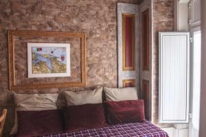 塞沙尔Legendary Bay Apartamento Temático的一间卧室设有石墙和一张带枕头的床。