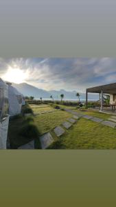 金塔马尼Igloo Glamping Bali的享有带凉亭的田野和日落美景
