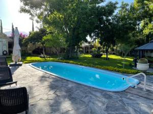 帕拉斯德拉富恩特Finca del Rocio的庭院内的游泳池,配有桌椅