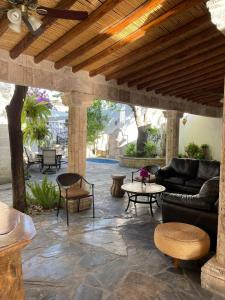 帕拉斯德拉富恩特Finca del Rocio的一个带沙发和桌子的庭院和木制天花板