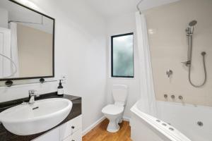 阿卡罗阿Woodside - Akaroa Holiday Cottage的白色的浴室设有水槽、浴缸和卫生间。